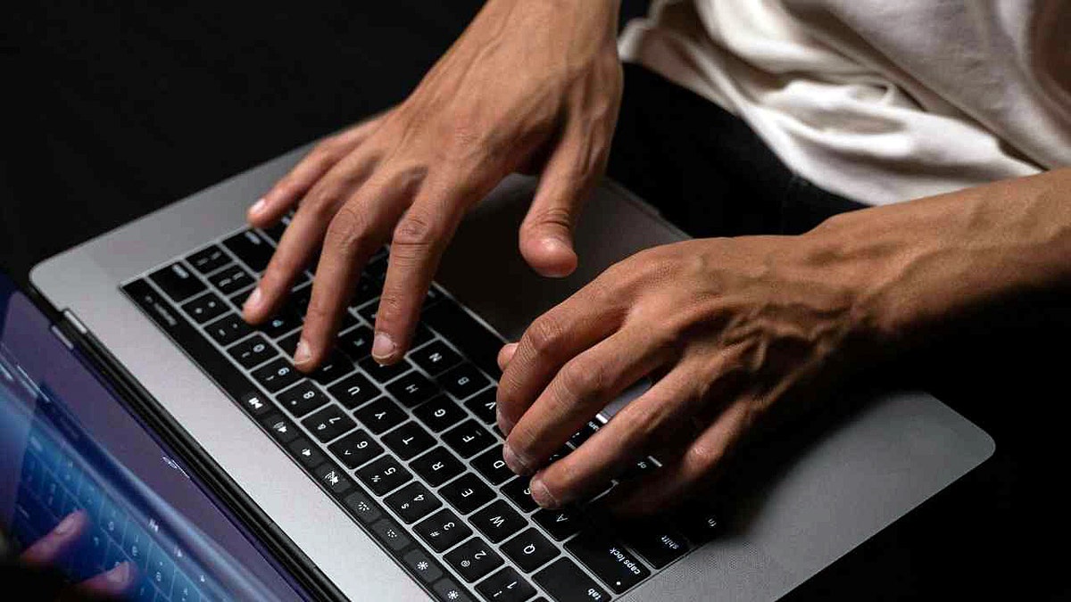 A man typing on a laptop