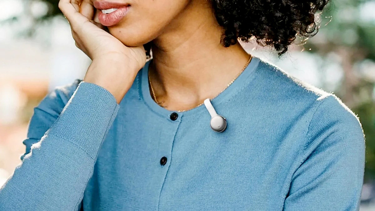 The tiny MindClip clipped on a woman's blue sweater.