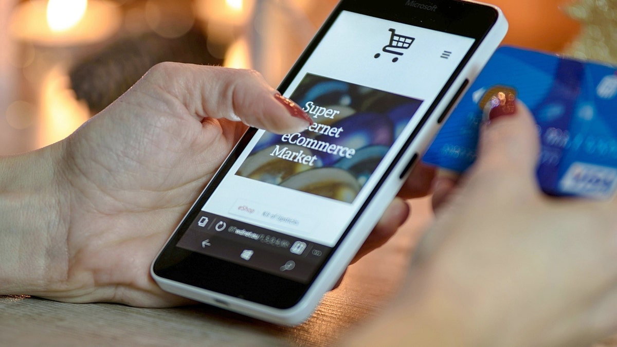 A person holding a phone while shopping online
