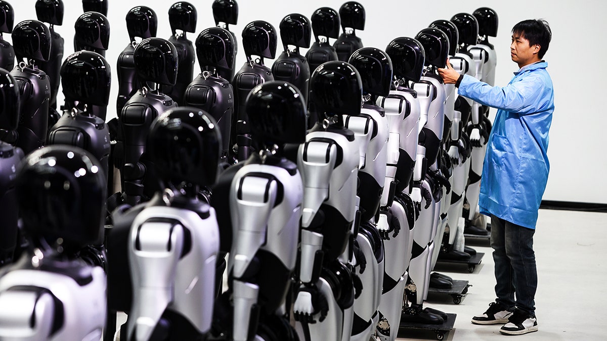 A tech in a room full of robots.