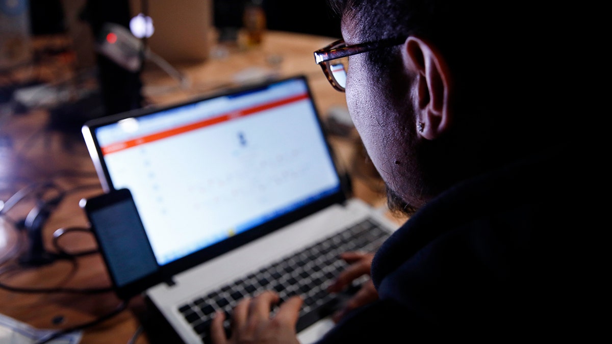 Person typing on their laptop.