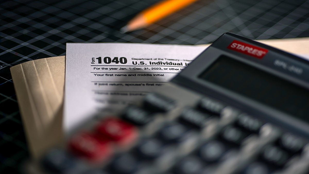 Tax forms and a calculator on a desk.