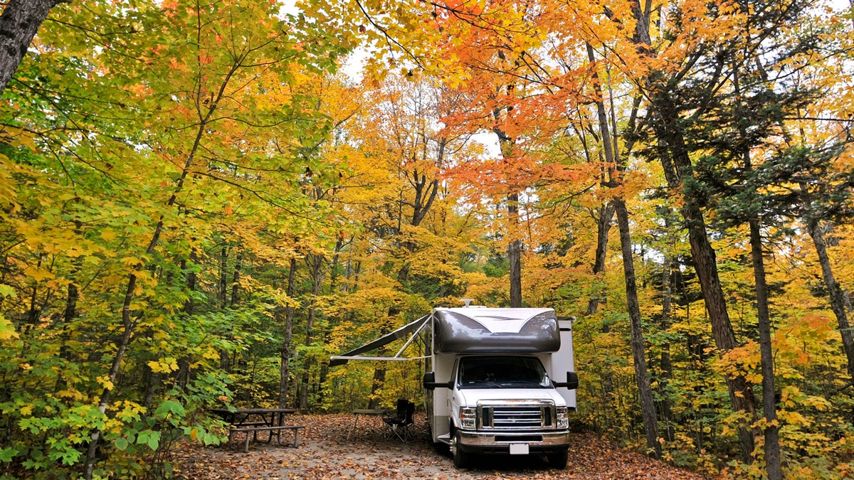 An RV parked in a campsite during the early autumn. 