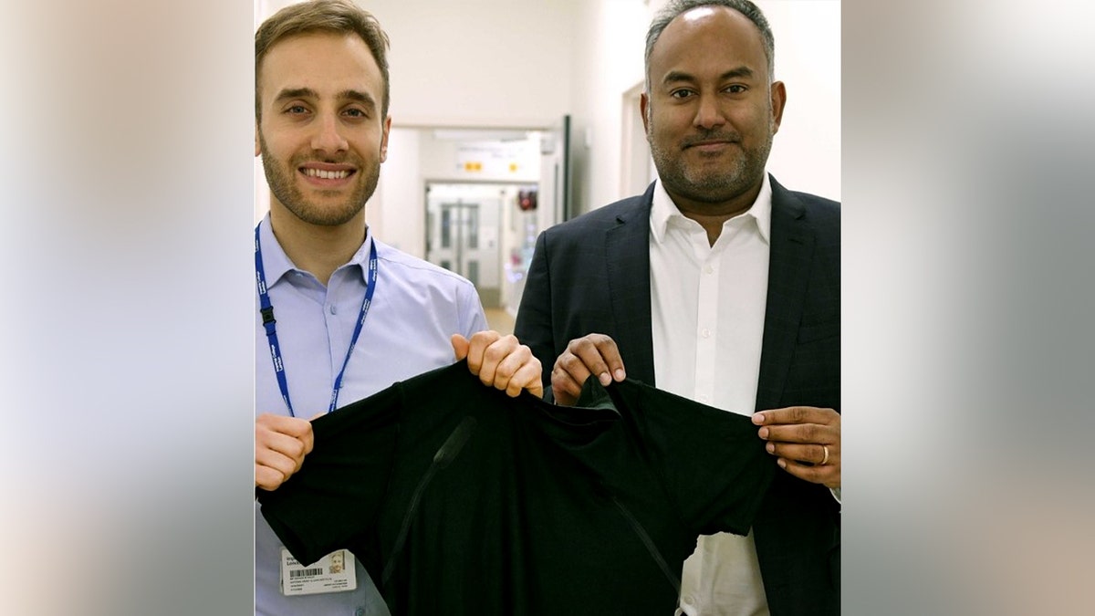 Two men holding up a shirt