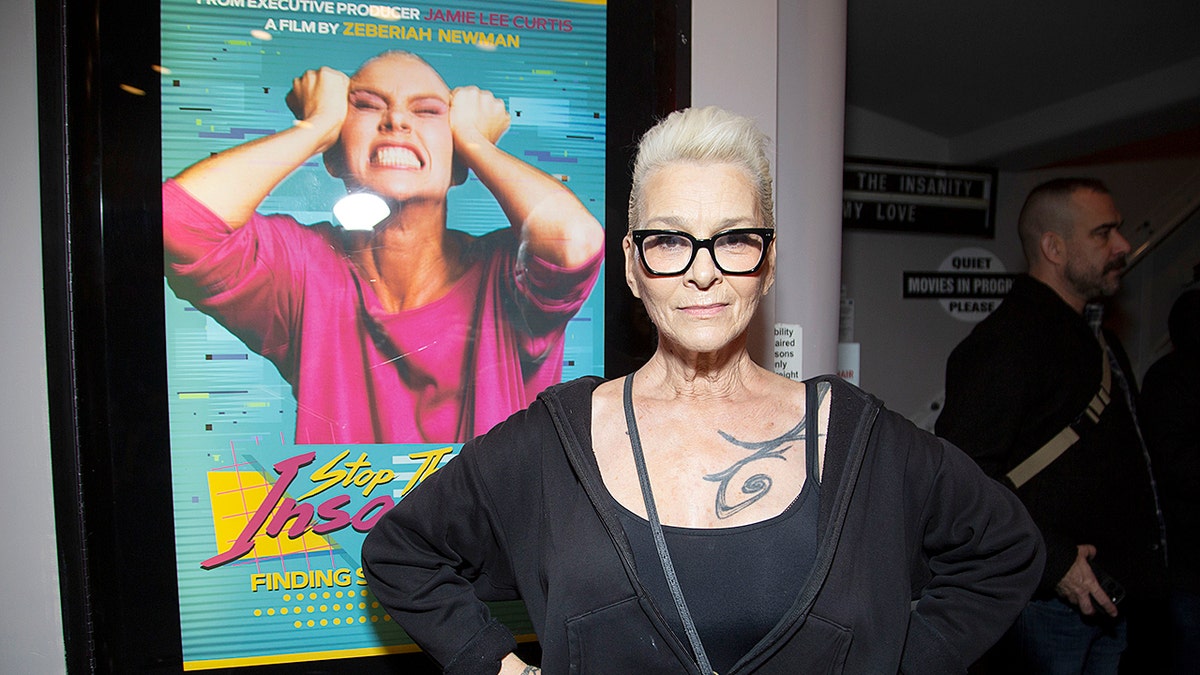 Susan Powter standing in front of a movie poster